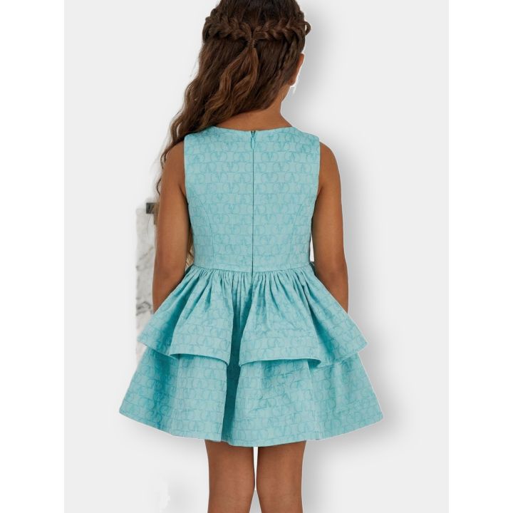 Bambina di spalle con l'abito celeste e la zip sul retro