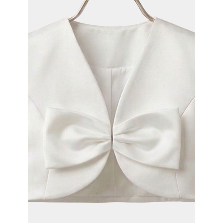 Dettaglio del maxi fiocco centrale del bolero bianco