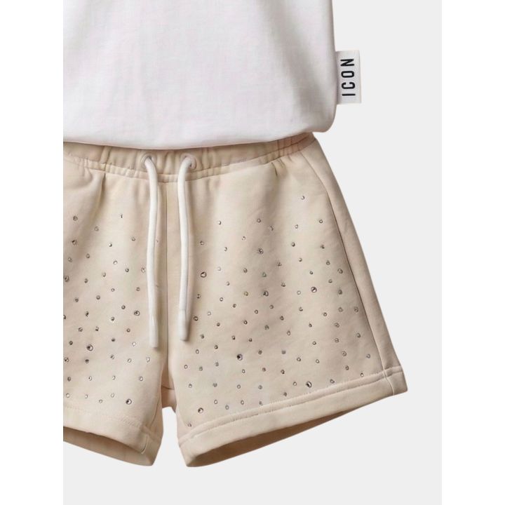 Dettaglio degli short crema con brillantini e coulisse bianca