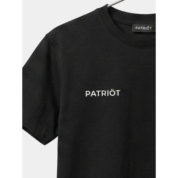Dettaglio del piccolo logo bianco Patriot sul petto della t-shirt nera