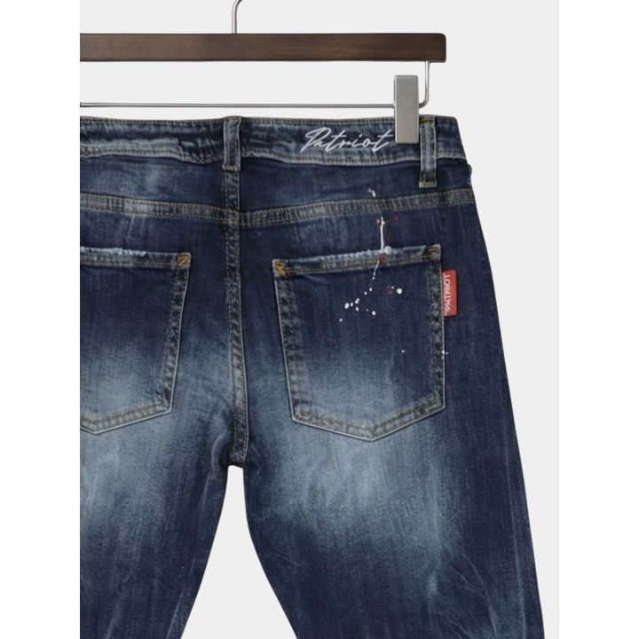 Dettaglio della scritta Patriot in corsivo in vita sul retro dei jeans blu