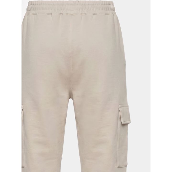 Dettaglio della vita elastica e della tasca cargo del pantalone beige
