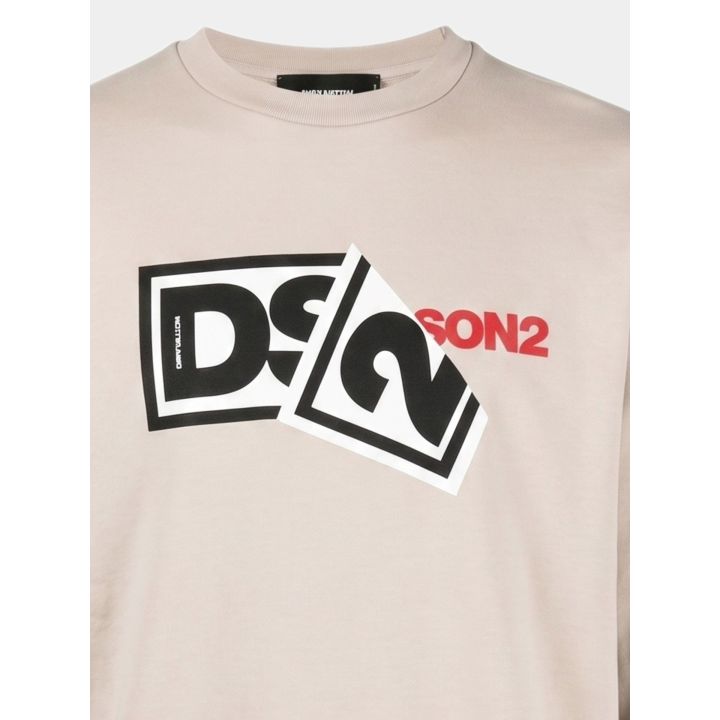 Dettaglio del logo DS2 a riquadri con scritta rossa sulla felpa beige