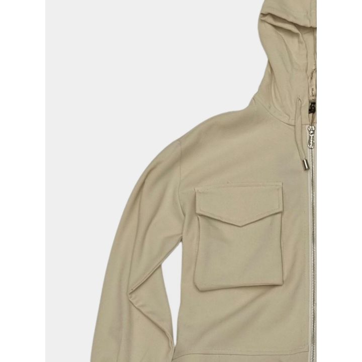 Dettaglio della tasca con patta e della zip della giacca beige