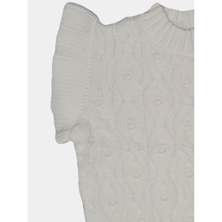 Dettaglio del volant in maglia sulla spalla color latte