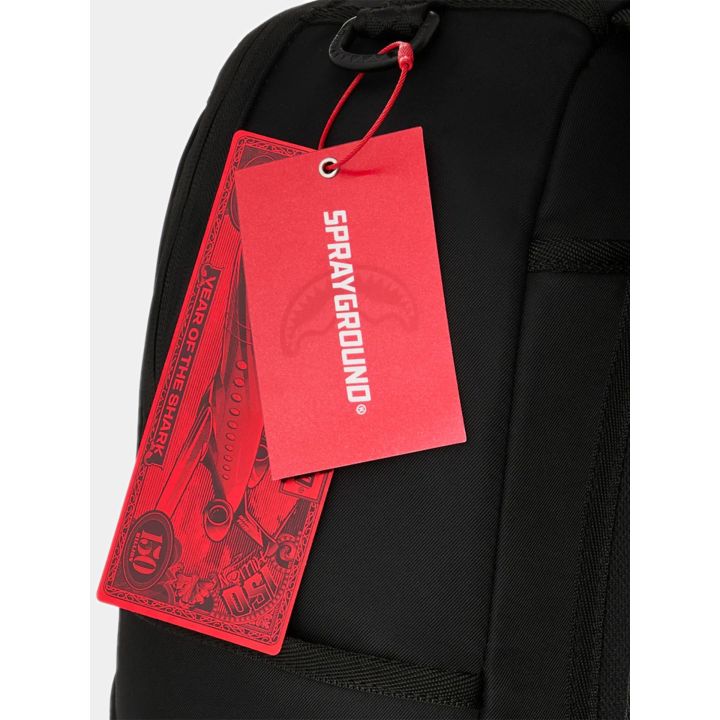 Dettaglio del cartellino rosso Sprayground sullo zaino nero