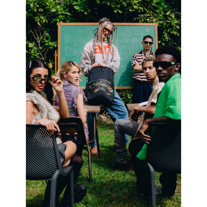 Gruppo di ragazzi in una classe all'aperto con lo zaino nero camouflage