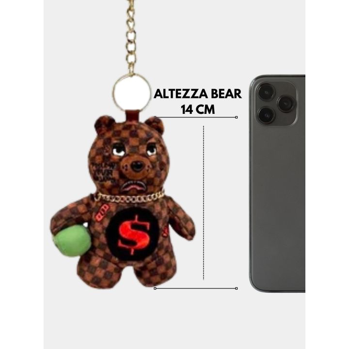 Portachiavi orsetto marrone accanto a uno smartphone per l'altezza