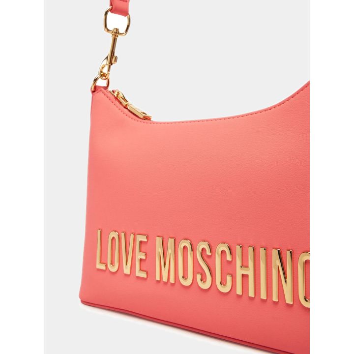 Dettaglio del maxi logo oro e del moschettone sulla borsa corallo