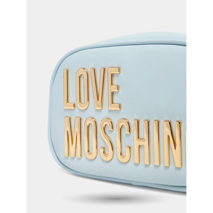 Dettaglio del maxi logo lettering oro sulla camera bag azzurra
