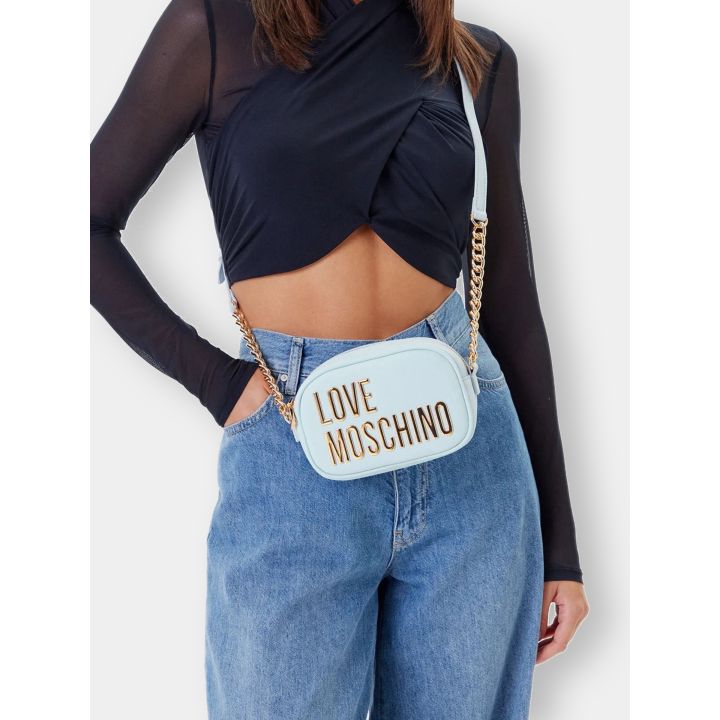 Borsa Love Moschino azzurra indossata a tracolla con catena dorata