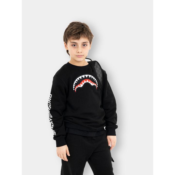 Ragazzo con la felpa girocollo Sprayground nera e lo squalo sul petto