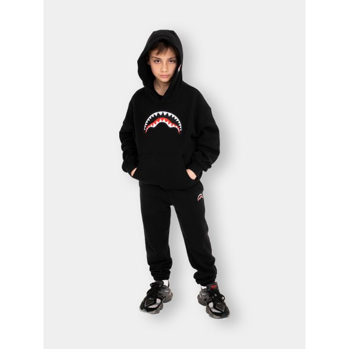 Ragazzo con la felpa Sprayground nera e il cappuccio alzato