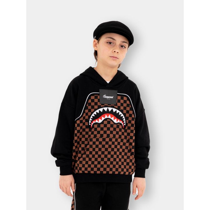 Ragazzo con la felpa con cappuccio Sprayground a scacchi, vista frontale