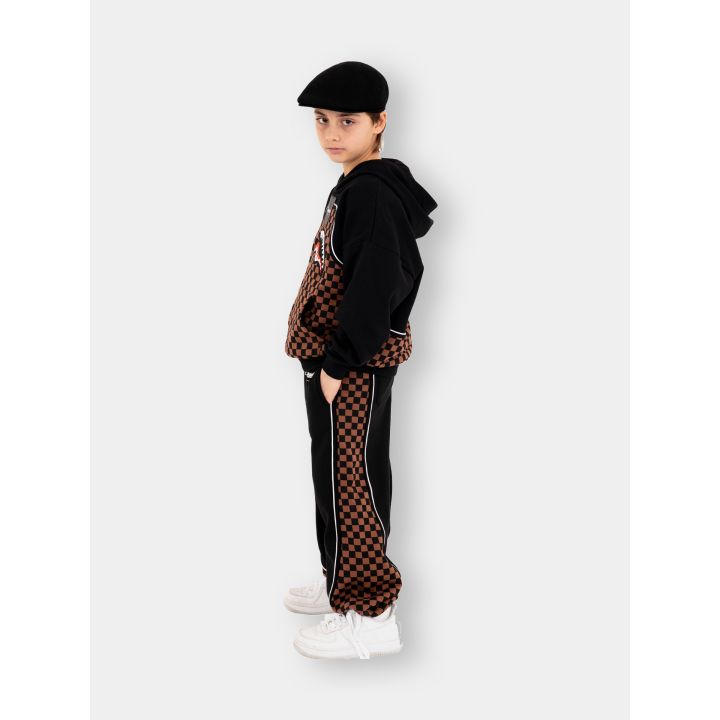 Ragazzo di profilo con la felpa Sprayground nera e marrone