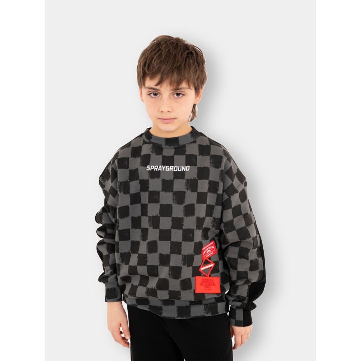 Ragazzo con la felpa Sprayground indossata sul lato a scacchi grigi