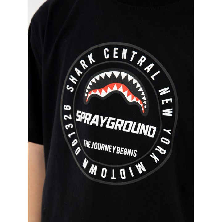 Logo tondo bianco con squalo rosso sulla t-shirt indossata