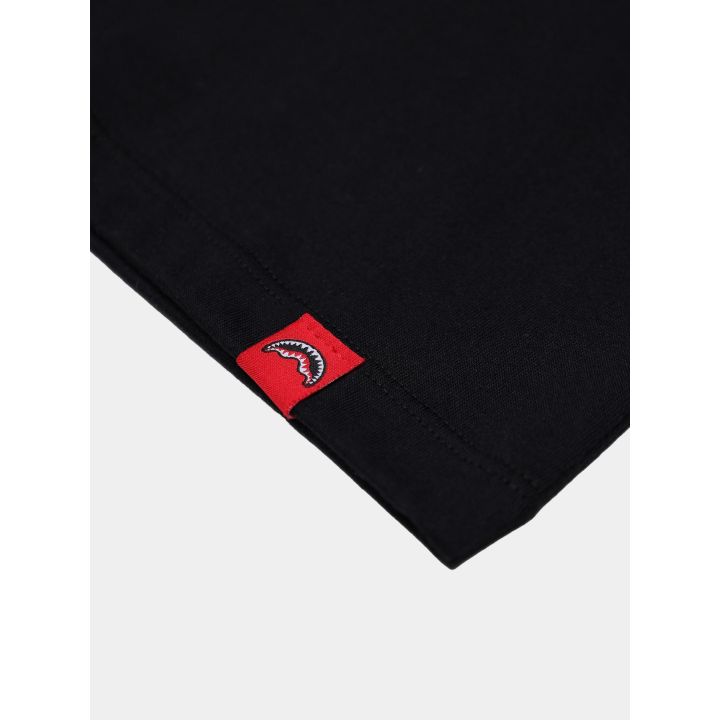 Etichetta rossa tessuta con lo squalo sul fondo della t-shirt nera