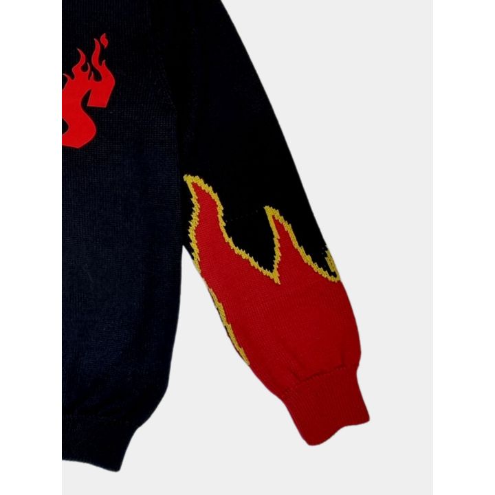 Dettaglio delle fiamme lavorate a maglia sulla manica del maglione