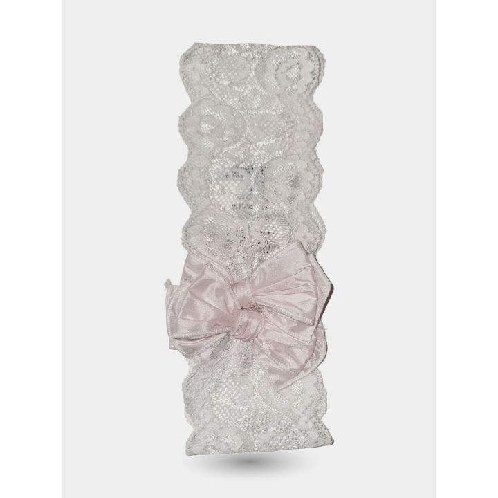 Fascia in pizzo bianco distesa con il fiocco rosa in primo piano