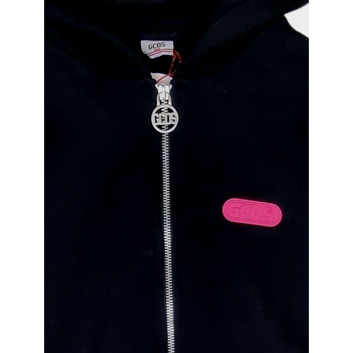 Dettaglio della zip con tiretto a medaglione GCDS e placca fucsia