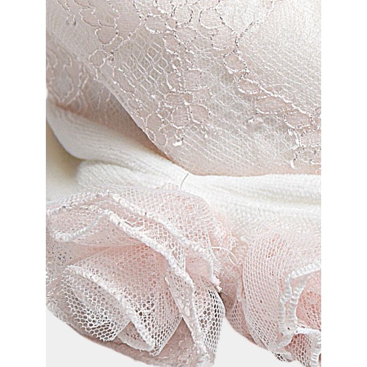 Dettaglio delle due rose di tulle rosa sulla fascia panna