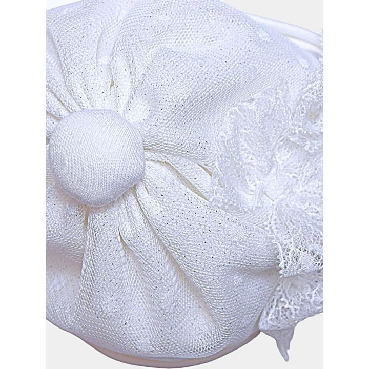 Dettaglio del bottoncino rivestito in cima al cappello bianco