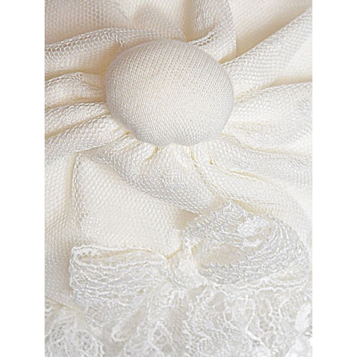 Dettaglio della pallina di stoffa in cima al cappellino in tulle