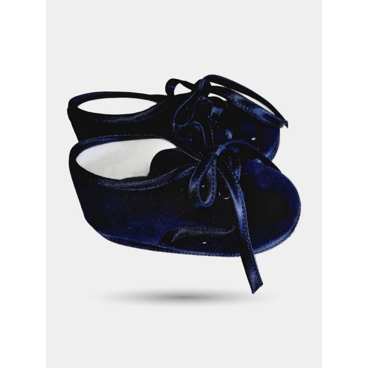 Scarpine blu di profilo con fodera bianca e nastri annodati a fiocco