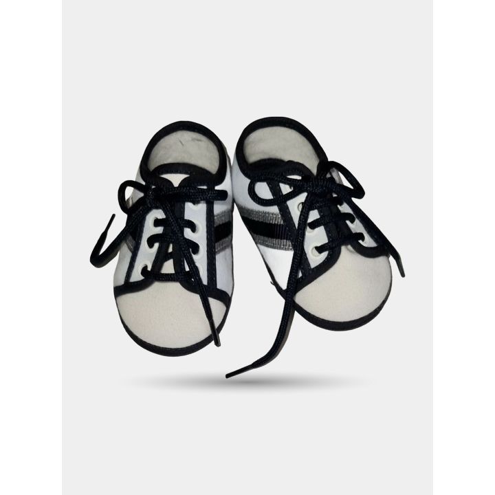 Scarpe da cerimonia Aletta bianche da neonato viste dall'alto con lacci scuri