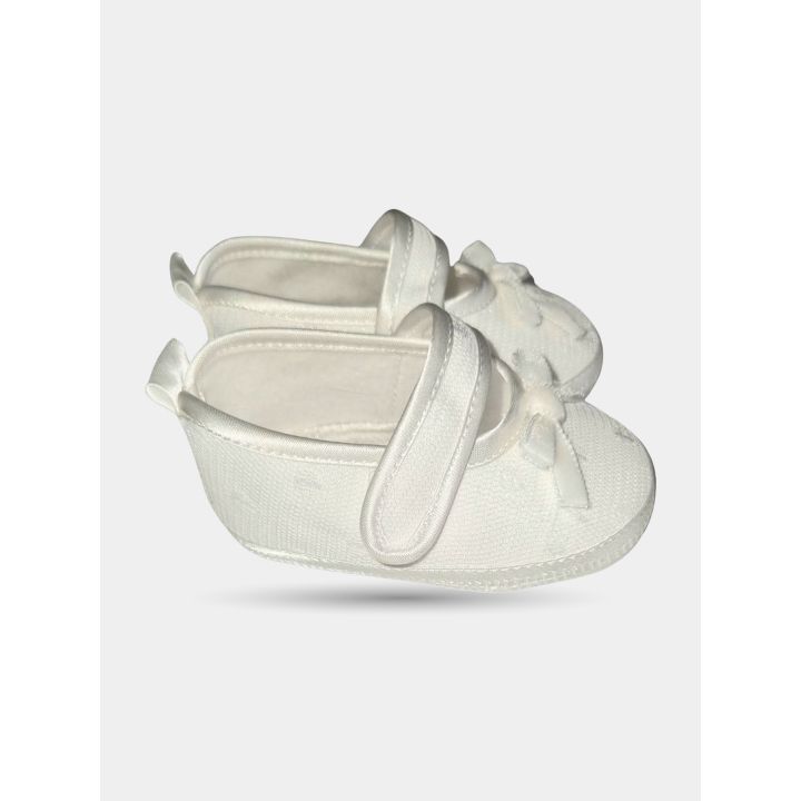 Scarpine bianche viste di lato con cinturino lucido a strappo